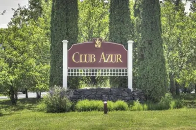 a sign for a club azur in a park at Le Philémon Club Azur plage Memphrémagog in Magog-Orford