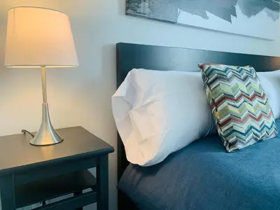 a bed with a pillow and a lamp on a table at Le Philémon Club Azur plage Memphrémagog in Magog-Orford