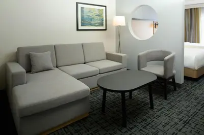 a living room with a couch and a table and a bed at Fairfield Inn & Suites by Marriott Montreal Airport in Dorval