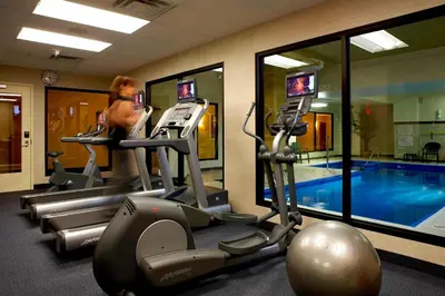 a woman in a gym with a swimming pool at Fairfield Inn & Suites by Marriott Montreal Airport in Dorval