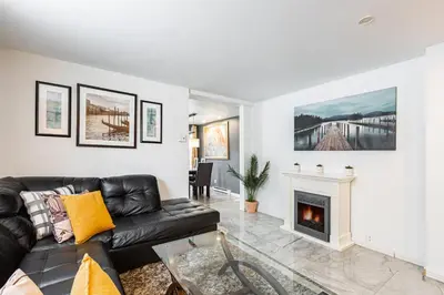a living room with a black leather couch and a fireplace at Chez Joe - CITQ #3I74I4 in Terrebonne
