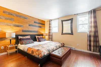 a bedroom with a bed and a wooden wall at Chez Joe - CITQ #3I74I4 in Terrebonne