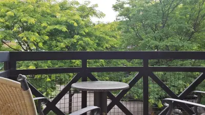 a table and chairs on a balcony with trees at Hotel Chateau Bromont in Bromont