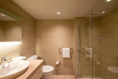 a bathroom with a shower and a toilet and a sink at Hotel Chateau Bromont in Bromont