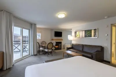 a hotel room with a bed and a living room at Hotel Chateau Bromont in Bromont
