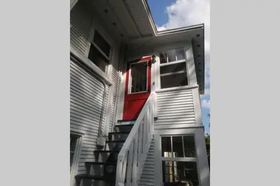 a house with a red door and stairs on it at L'Alcôve des Céramistes in Waterloo