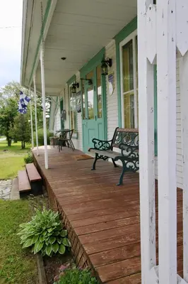 a porch of a house with a bench on it at À la croisée des sommets in Notre-Dame-Des-Bois