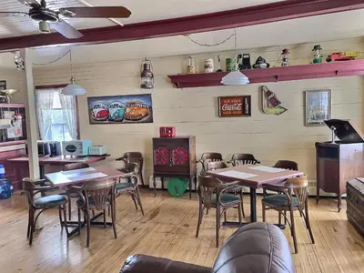 a restaurant with tables and chairs in a room at À la croisée des sommets in Notre-Dame-Des-Bois