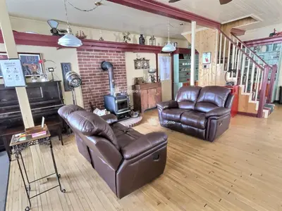 a living room with leather furniture and a fireplace at À la croisée des sommets in Notre-Dame-Des-Bois