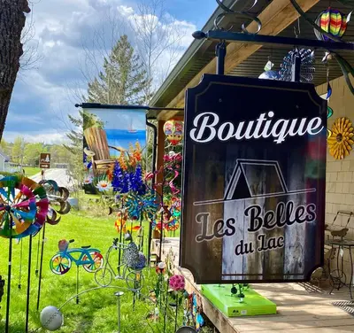 a sign for a boutique les belles du lane at À la croisée des sommets in Notre-Dame-Des-Bois
