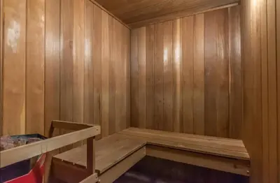 an empty sauna with wooden walls and a shelf at Magog Waterfront Studio 106 in Magog-Orford