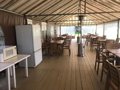 a restaurant with tables and chairs and a refrigerator at Magog Waterfront Studio 106 in Magog-Orford
