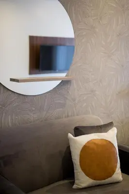 a couch with a pillow and a mirror on a wall at Blue Oasis Studio with Full Kitchen and Bath by Den Stays in Montréal