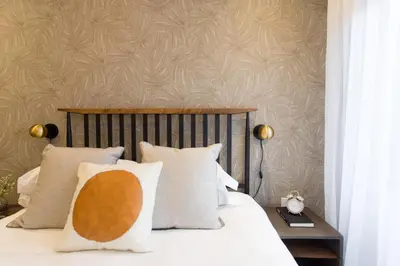a bedroom with a bed with white pillows at Blue Oasis Studio with Full Kitchen and Bath by Den Stays in Montréal