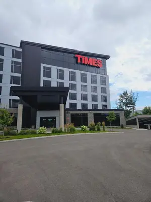 a building with a times sign on top of it at Grand Hotel TiMES Blainville-Mirabel in Blainville