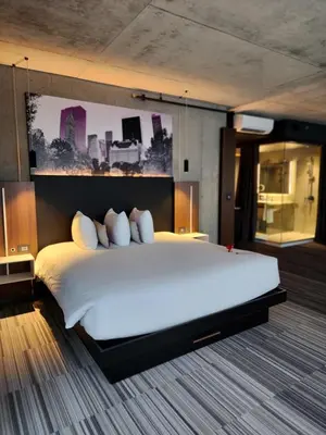 a large white bed in a hotel room at Grand Hotel TiMES Blainville-Mirabel in Blainville