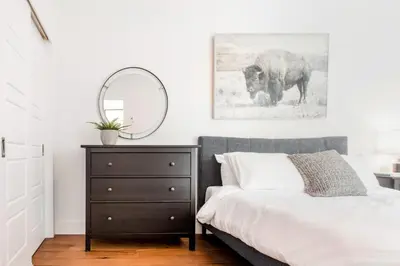 a bedroom with a bed with a mirror and a dresser at Hip, Stylish Apartment In Little Italy by Den Stays in Montréal