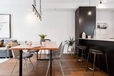 a kitchen with a table and chairs in a room at Hip, Stylish Apartment In Little Italy by Den Stays in Montréal