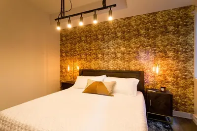 a bedroom with a bed and a wall with lights at Huge 2 Bdr with Balcony in Mile End by Den Stays in Montréal