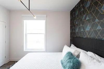 a bedroom with a white bed with a black headboard at Stunning 1 Bedroom in Mile End by Den Stays in Montréal