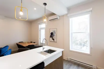 a kitchen with a sink and a table and a window at Stunning 1 Bedroom in Mile End by Den Stays in Montréal