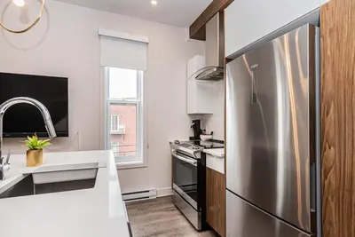 a kitchen with a stainless steel refrigerator at 2 Bedroom Luxury in the Mile End by Den Stays in Montréal