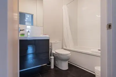 a bathroom with a toilet and a sink and a tub at 2 Bedroom Luxury in the Mile End by Den Stays in Montréal