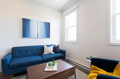 a living room with a blue couch and a coffee table at Perfectly Located Mile End 2 Bdr Unit by Den Stays in Montréal