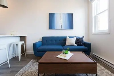 a living room with a blue couch and a coffee table at Perfectly Located Mile End 2 Bdr Unit by Den Stays in Montréal