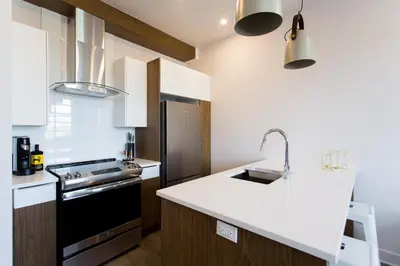 a kitchen with a sink and a stove top oven at Perfectly Located Mile End 2 Bdr Unit by Den Stays in Montréal