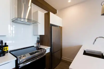 a small kitchen with a stove and a sink at Perfectly Located Mile End 2 Bdr Unit by Den Stays in Montréal