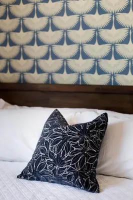 a black pillow sitting on a bed with a wall at Perfectly Located Mile End 2 Bdr Unit by Den Stays in Montréal