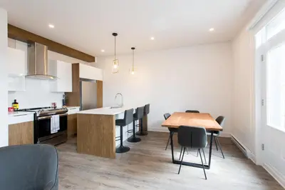 a kitchen and dining room with a table and chairs at Light Filled 2 Bdr Unit in Mile End by Den Stays in Montréal