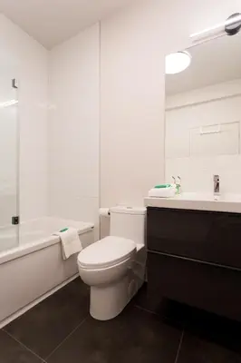 a bathroom with a toilet and a sink and a tub at Light Filled 2 Bdr Unit in Mile End by Den Stays in Montréal