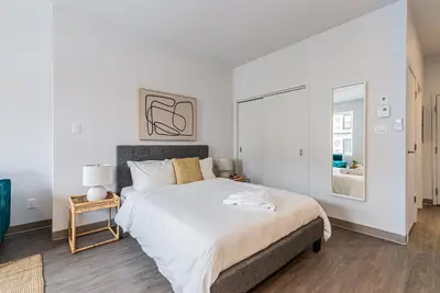a white bedroom with a large bed and a window at Brand New and Perfectly Located Flat in Le Plateau by Den Stays in Montréal