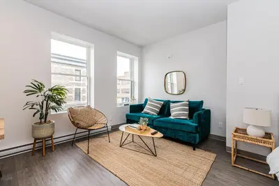 a living room with a blue couch and a window at Brand New and Perfectly Located Flat in Le Plateau by Den Stays in Montréal