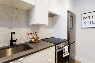 a kitchen with a sink and a stove at Studio Palms Steps from JeanTalon Market Full Bath by Den Stays in Montréal