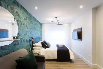 a bedroom with a bed and a couch at Studio Palms Steps from JeanTalon Market Full Bath by Den Stays in Montréal
