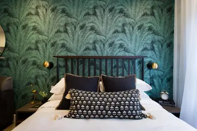 a bedroom with a bed with a green wallpaper at Studio Palms Steps from JeanTalon Market Full Bath by Den Stays in Montréal