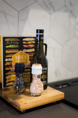 a counter with two bottles of food on a cutting board at Romantic Studio in the Heart of Little Italy by Den Stays in Montréal