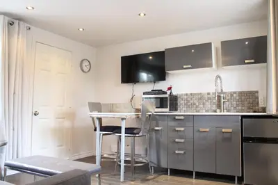 a kitchen with a counter and a table with chairs at Le Marigot in Vaudreuil-Dorion