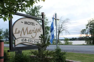 a sign for a motellorle market with two flags at Le Marigot in Vaudreuil-Dorion