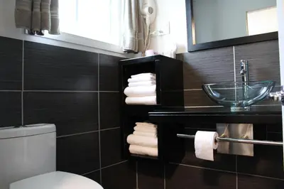 a bathroom with a sink and a toilet and towels at Le Marigot in Vaudreuil-Dorion