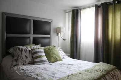 a bedroom with a large bed and a window at Le Marigot in Vaudreuil-Dorion