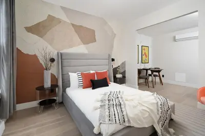 a bedroom with a bed with a painting on the wall at François-Denis Apartments in Montréal