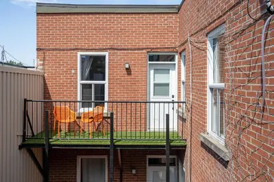 a balcony of a brick building with two chairs on it at François-Denis Apartments in Montréal