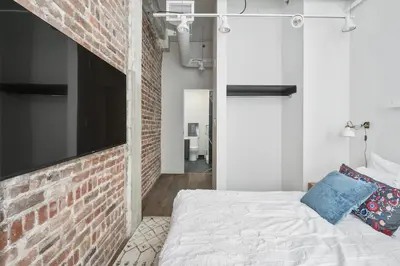 a bedroom with a brick wall and a bed at Bakan - Sainte Catherine in Montréal