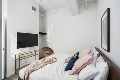a bedroom with a bed with pillows and a tv at Bakan - Sainte Catherine in Montréal
