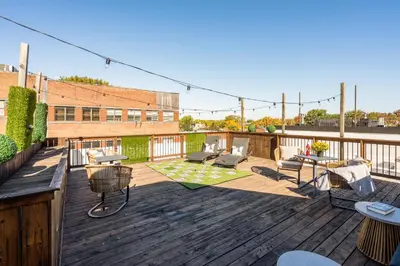 a deck with chairs and tables on top of a building at Hotel-Apart Prince Arthur in Montréal