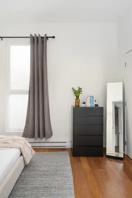 a bedroom with a bed and a dresser and a window at Hotel-Apart Prince Arthur in Montréal